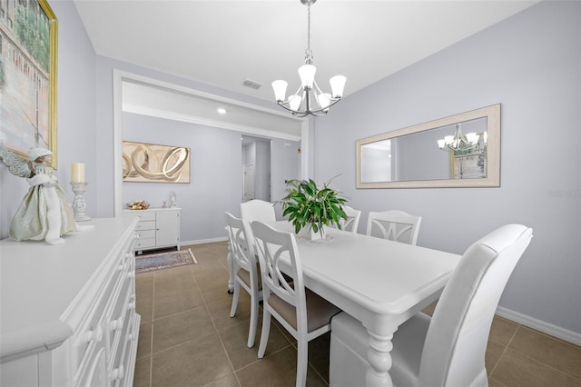 dining space with dark tile patterned flooring and a chandelier