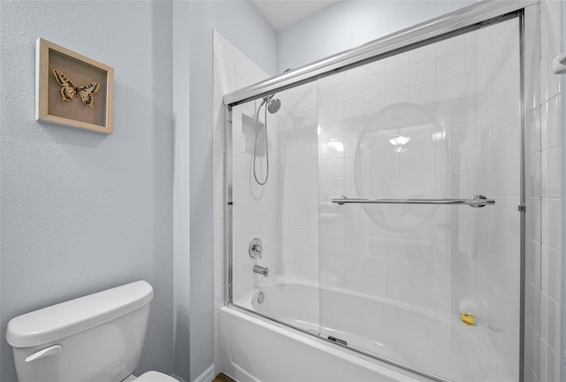 bathroom featuring toilet and combined bath / shower with glass door