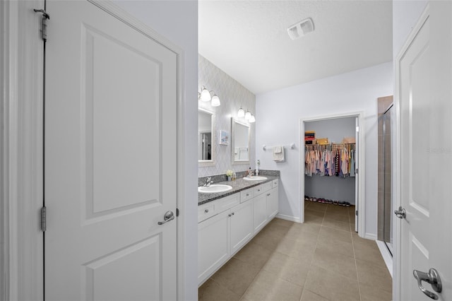 bathroom with vanity, tile patterned floors, and a shower with door