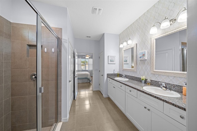 bathroom featuring vanity, ceiling fan, a textured ceiling, and a shower with door