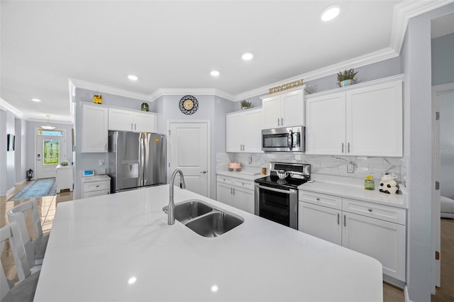 kitchen featuring sink, white cabinetry, ornamental molding, and appliances with stainless steel finishes