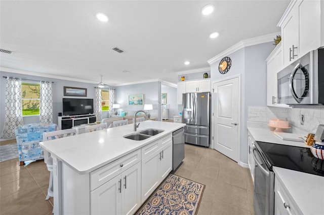 kitchen featuring crown molding, white cabinetry, sink, an island with sink, and stainless steel appliances