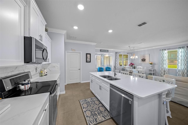 kitchen featuring white cabinetry, stainless steel appliances, an island with sink, sink, and a breakfast bar