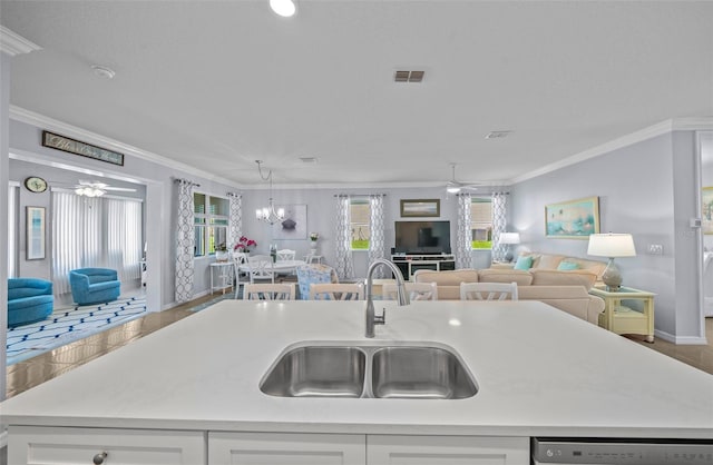 kitchen with sink, dishwashing machine, a kitchen island with sink, and crown molding