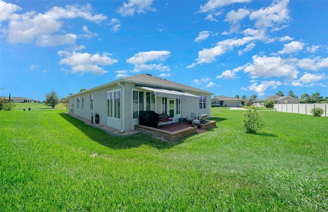 back of house with a yard and a patio