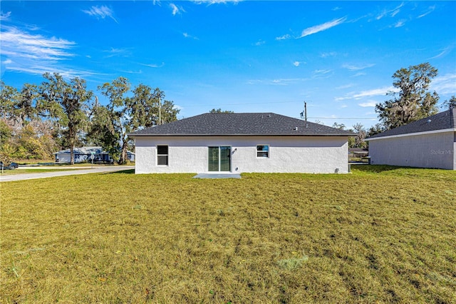 rear view of property with a lawn