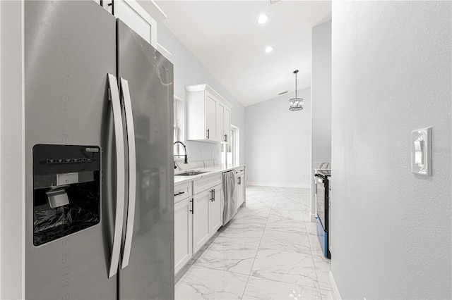 kitchen featuring stainless steel appliances, lofted ceiling, hanging light fixtures, and white cabinets