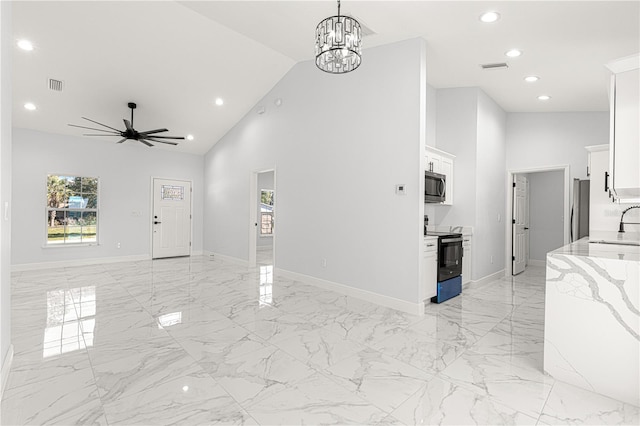 living room featuring sink, ceiling fan with notable chandelier, and high vaulted ceiling