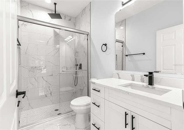 bathroom with vanity, a shower with shower door, and toilet