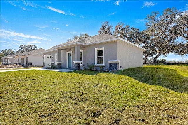 view of front of house with central AC, a garage, and a front lawn