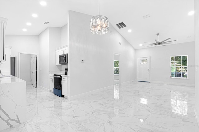 living room featuring ceiling fan with notable chandelier and high vaulted ceiling