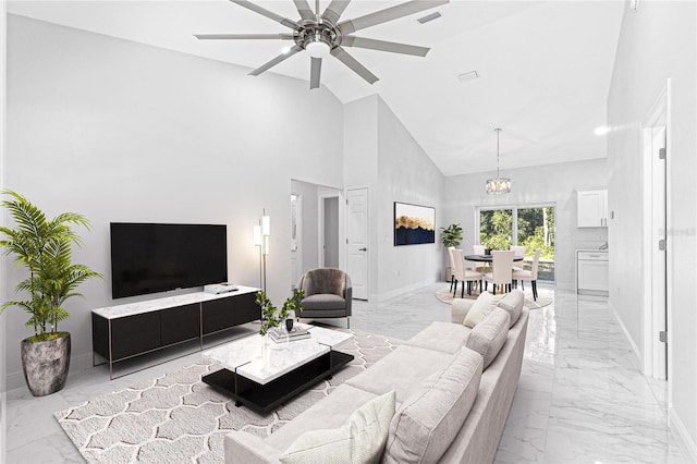 living room featuring ceiling fan with notable chandelier and high vaulted ceiling