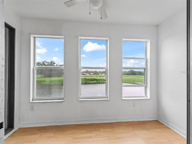 unfurnished room with light hardwood / wood-style floors, a wealth of natural light, and ceiling fan