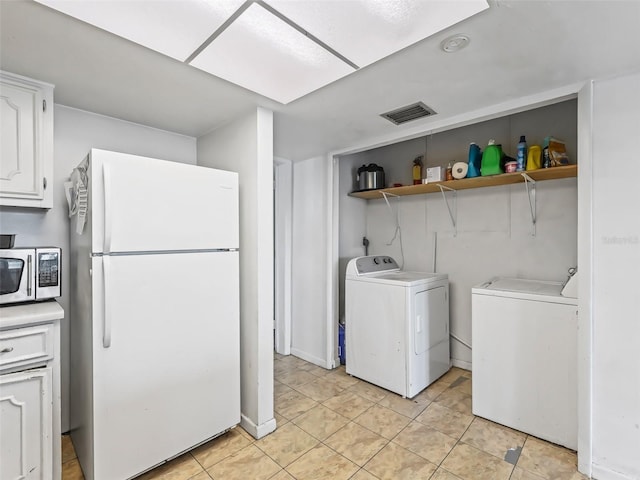 clothes washing area with separate washer and dryer and light tile patterned floors