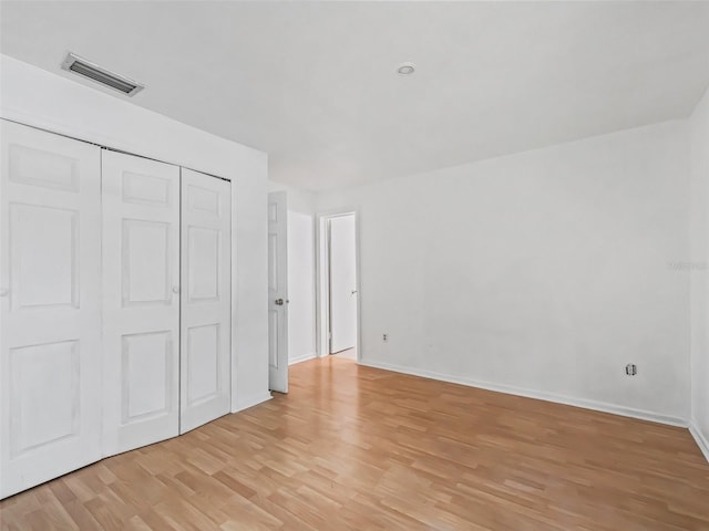 unfurnished bedroom with light hardwood / wood-style floors and a closet