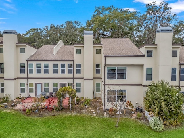 rear view of property with a yard and a patio