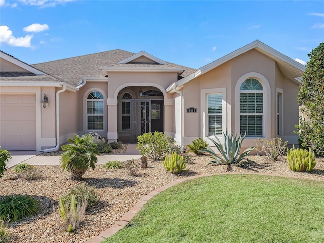 ranch-style home with a garage and a front lawn