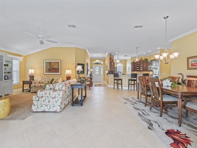 living room featuring light tile patterned floors, a wealth of natural light, ornamental molding, and vaulted ceiling