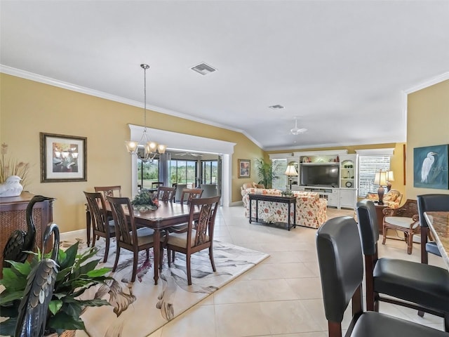 tiled dining area with lofted ceiling, crown molding, and ceiling fan with notable chandelier