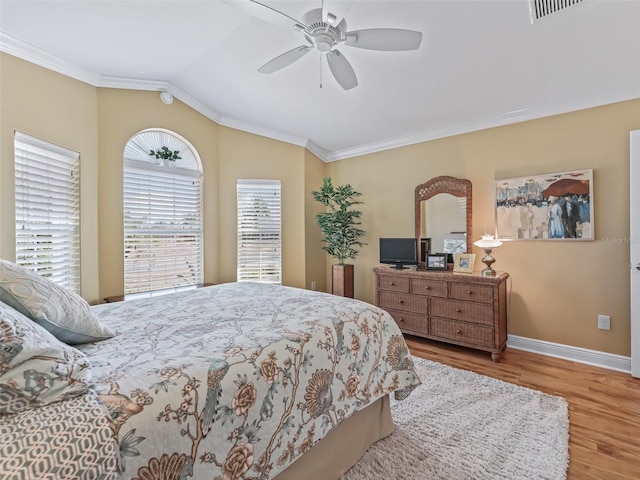 bedroom featuring hardwood / wood-style flooring, ornamental molding, lofted ceiling, and ceiling fan