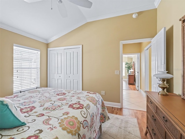 bedroom with lofted ceiling, ornamental molding, ceiling fan, light hardwood / wood-style floors, and a closet