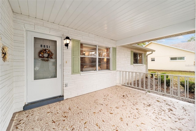 view of exterior entry featuring covered porch