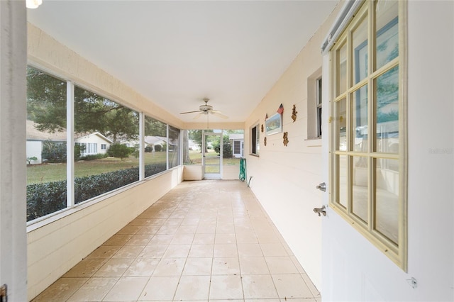 unfurnished sunroom with ceiling fan