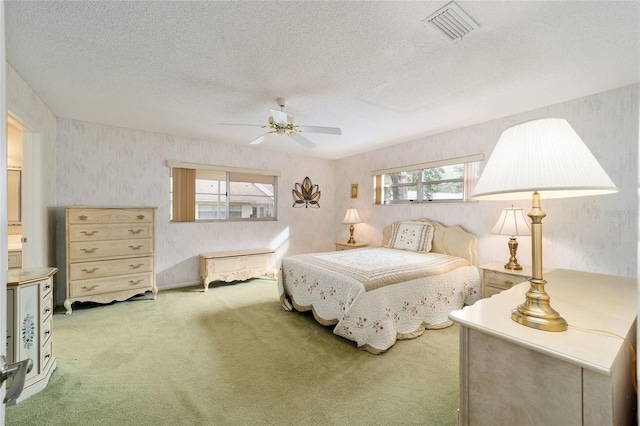 carpeted bedroom with ceiling fan, multiple windows, and a textured ceiling