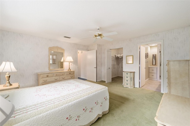 carpeted bedroom featuring a spacious closet, connected bathroom, a closet, and ceiling fan