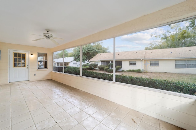 unfurnished sunroom with ceiling fan