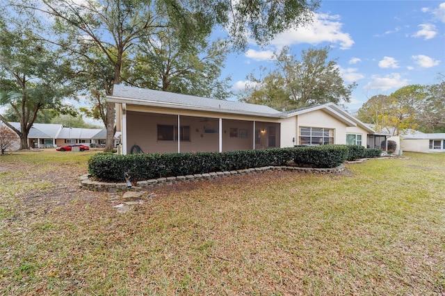 back of property featuring a sunroom and a yard