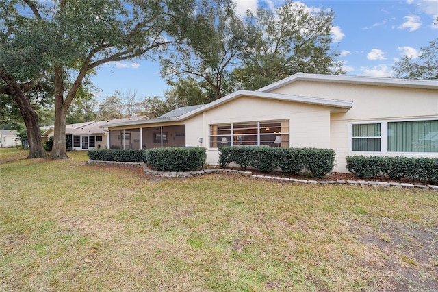 ranch-style home featuring a front yard and a sunroom