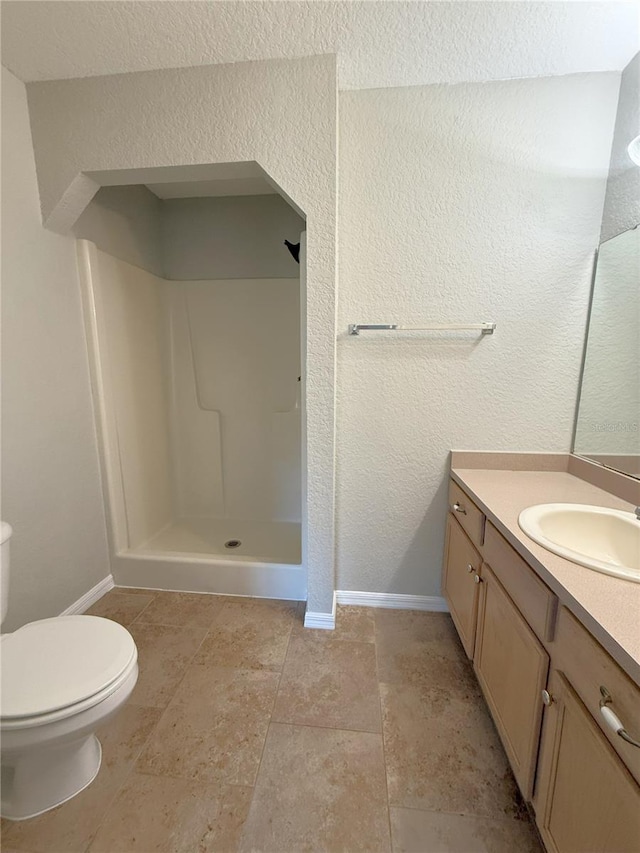 bathroom featuring vanity, toilet, and a shower