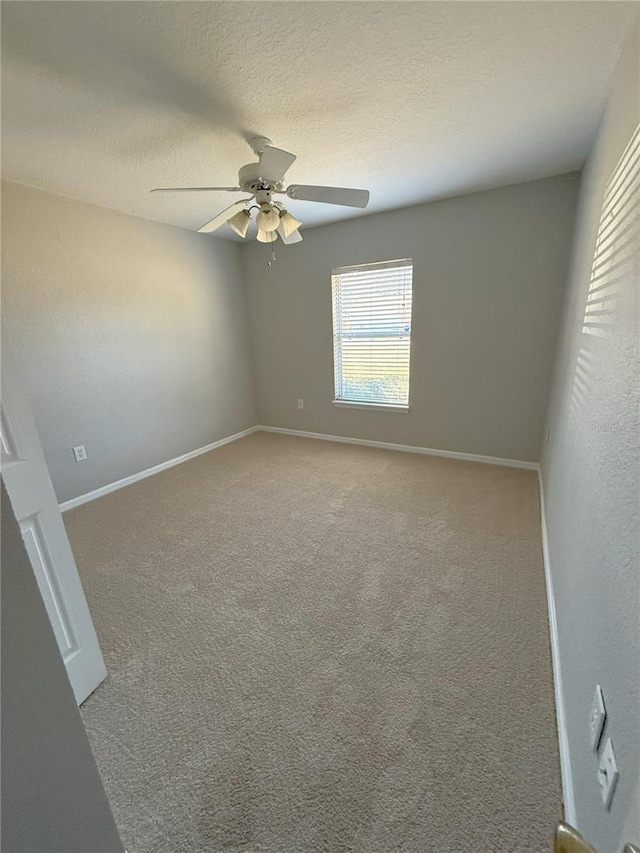 empty room with ceiling fan, carpet, and a textured ceiling