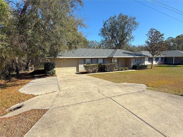 ranch-style home featuring a garage and a front lawn