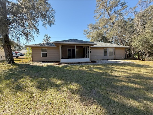 rear view of house with a yard and a sunroom