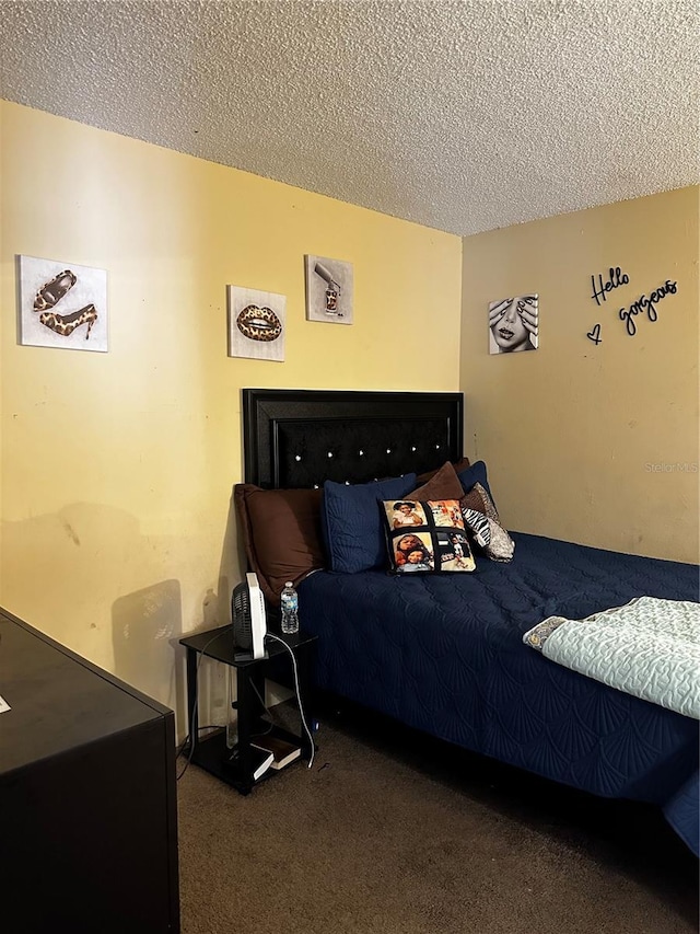 bedroom with dark carpet and a textured ceiling