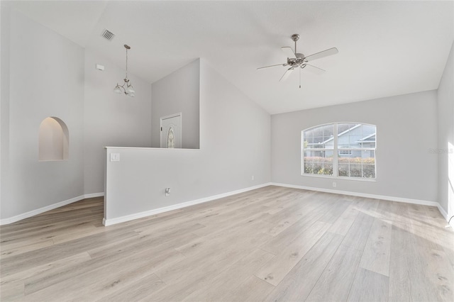 unfurnished living room with vaulted ceiling, ceiling fan with notable chandelier, and light hardwood / wood-style floors