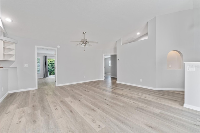 unfurnished living room with light wood-type flooring, ceiling fan, and vaulted ceiling