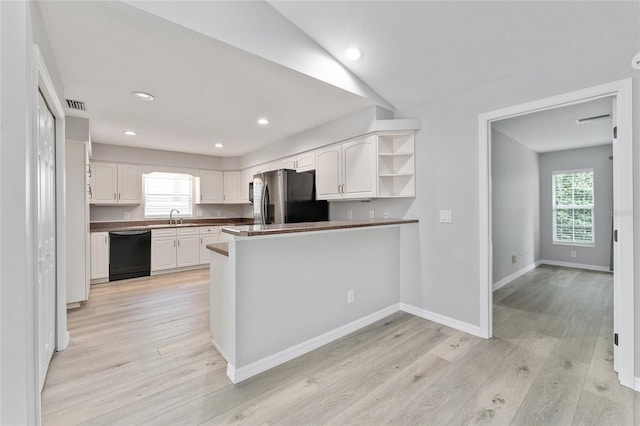 kitchen with black dishwasher, stainless steel refrigerator, white cabinets, sink, and kitchen peninsula