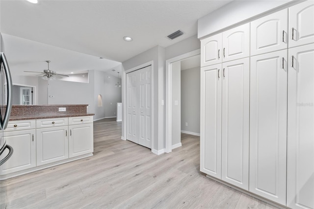 kitchen featuring ceiling fan, light hardwood / wood-style floors, and white cabinets