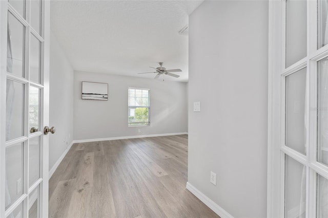 spare room with ceiling fan, a textured ceiling, and light hardwood / wood-style flooring