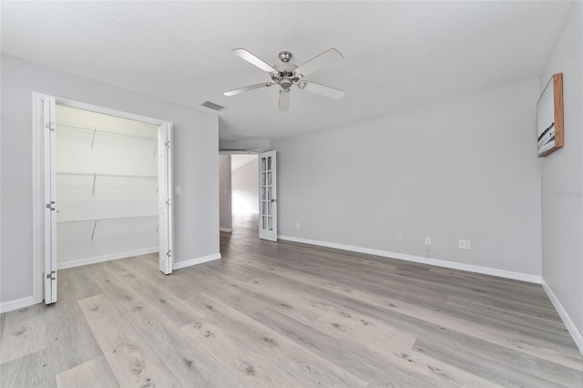 unfurnished bedroom featuring ceiling fan, light hardwood / wood-style floors, a textured ceiling, and a closet