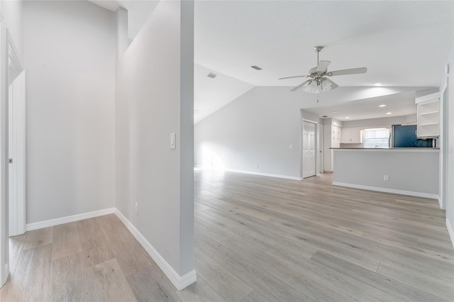 unfurnished living room with ceiling fan, lofted ceiling, and light wood-type flooring