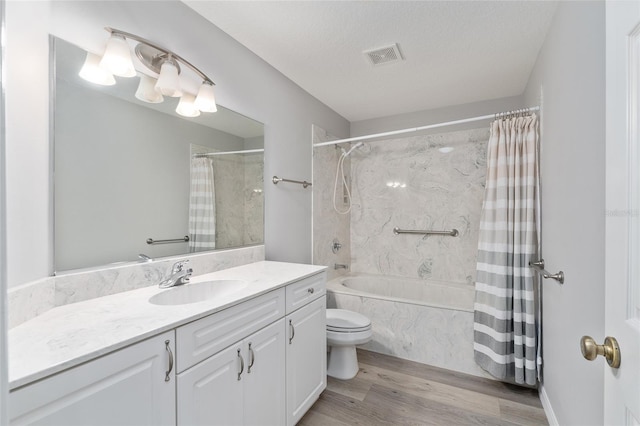 full bathroom featuring hardwood / wood-style flooring, toilet, a textured ceiling, shower / bath combination with curtain, and vanity