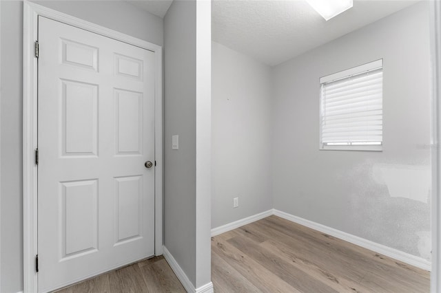 unfurnished room with a textured ceiling and light hardwood / wood-style flooring