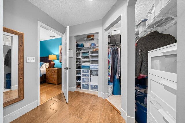 walk in closet with visible vents and wood finished floors