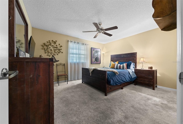 bedroom with carpet, baseboards, ceiling fan, and a textured ceiling