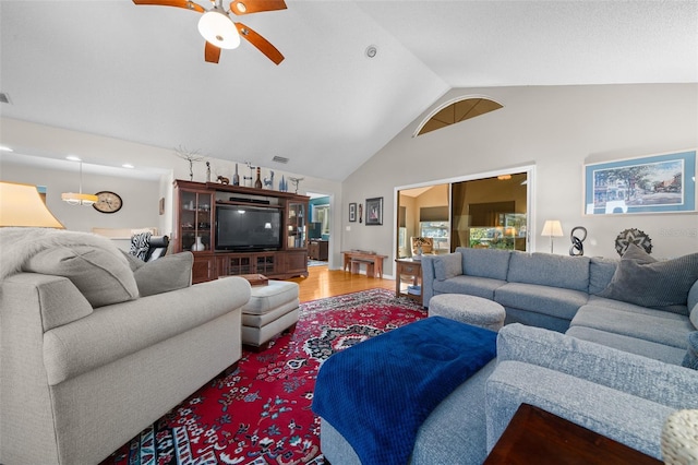 living area with high vaulted ceiling, visible vents, ceiling fan, and wood finished floors