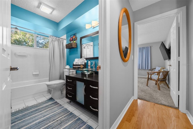 bathroom featuring toilet, a textured ceiling, and vanity